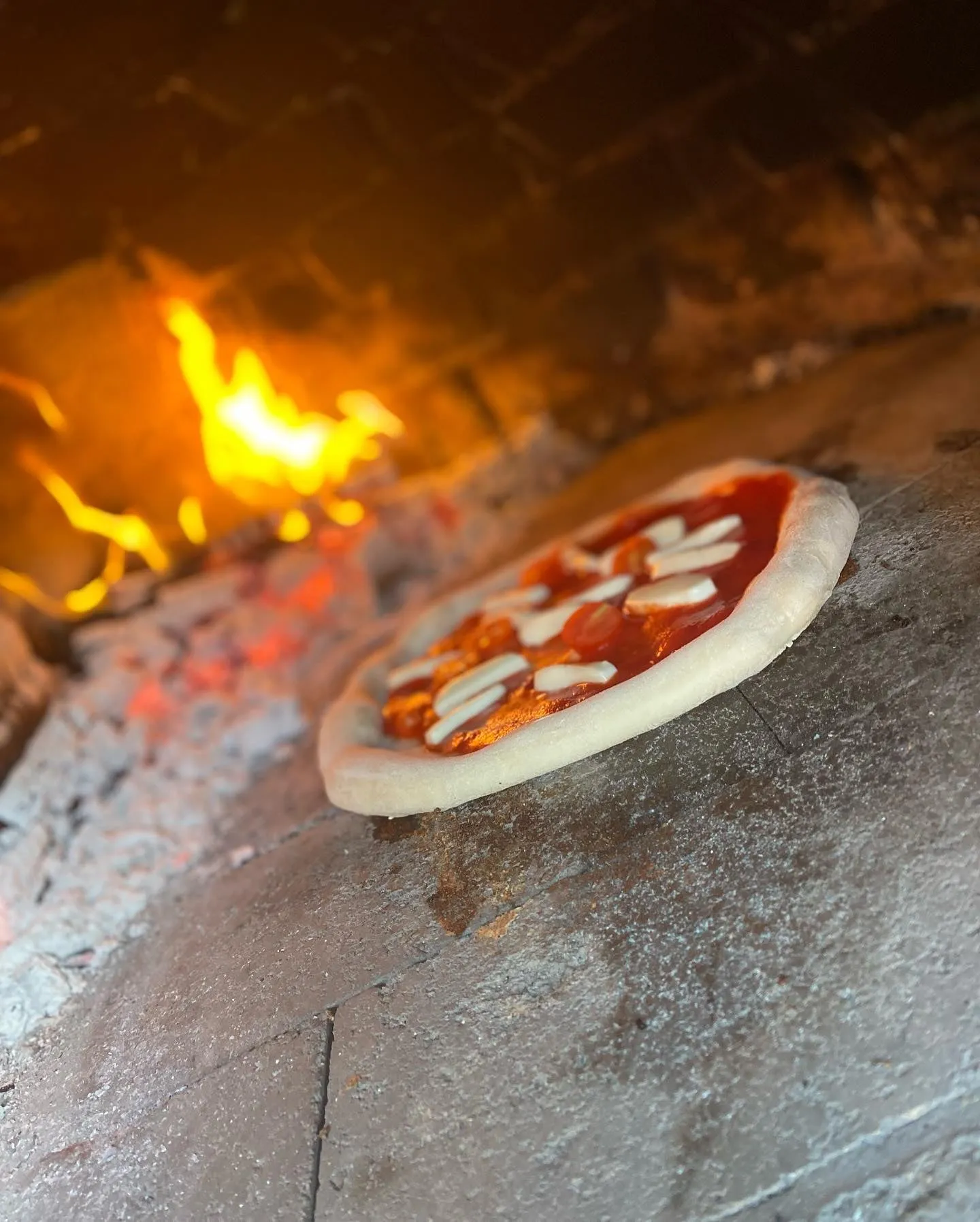Pizza nel forno a legna